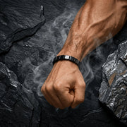 Pulseira Orion™ no pulso sobre uma superfície de pedra